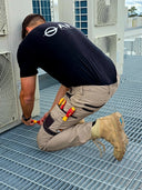 Australian plumber wearing DFP Workwear PP3 stretch canvas work pants while installing plumbing on a construction site.
