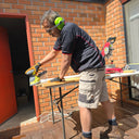 Australian carpenter wearing DFP Workwear PP3 stretch canvas work pants while measuring timber on a construction site.